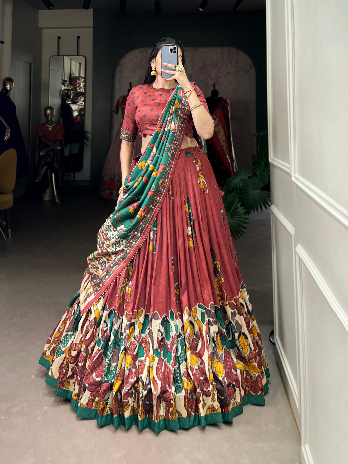 Red Tussar silk lehenga with Kalamkari print work, adorned with vibrant traditional motifs for a bold and festive look.