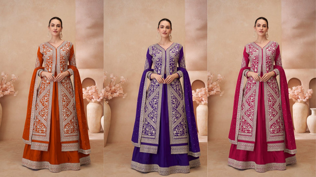 Three designer Anarkali gowns in rust-orange, royal purple, and magenta, each featuring intricate silver embroidery and matching embellished dupattas displayed in a studio setup.