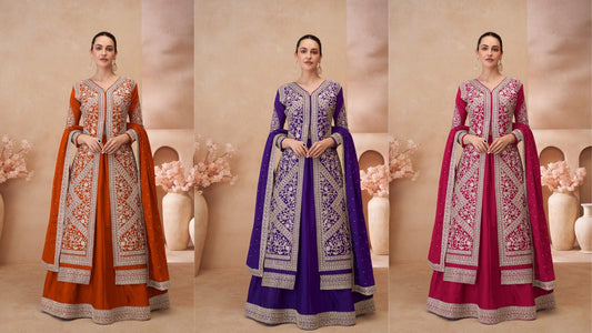 Three designer Anarkali gowns in rust-orange, royal purple, and magenta, each featuring intricate silver embroidery and matching embellished dupattas displayed in a studio setup.