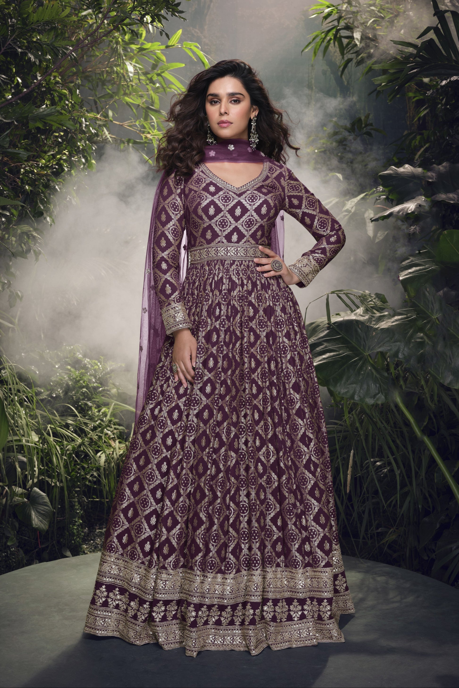 Dark purple Anarkali gown in viscose jacquard silk with embroidery work, complemented by a net dupatta for a rich and graceful festive look.
