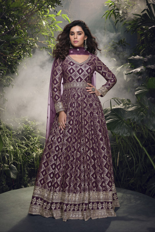 Dark purple Anarkali gown in viscose jacquard silk with embroidery work, complemented by a net dupatta for a rich and graceful festive look.
