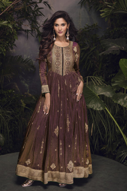 Dark brown Anarkali gown in viscose jacquard silk with embroidery work, paired with a net dupatta for an elegant festive ensemble.
