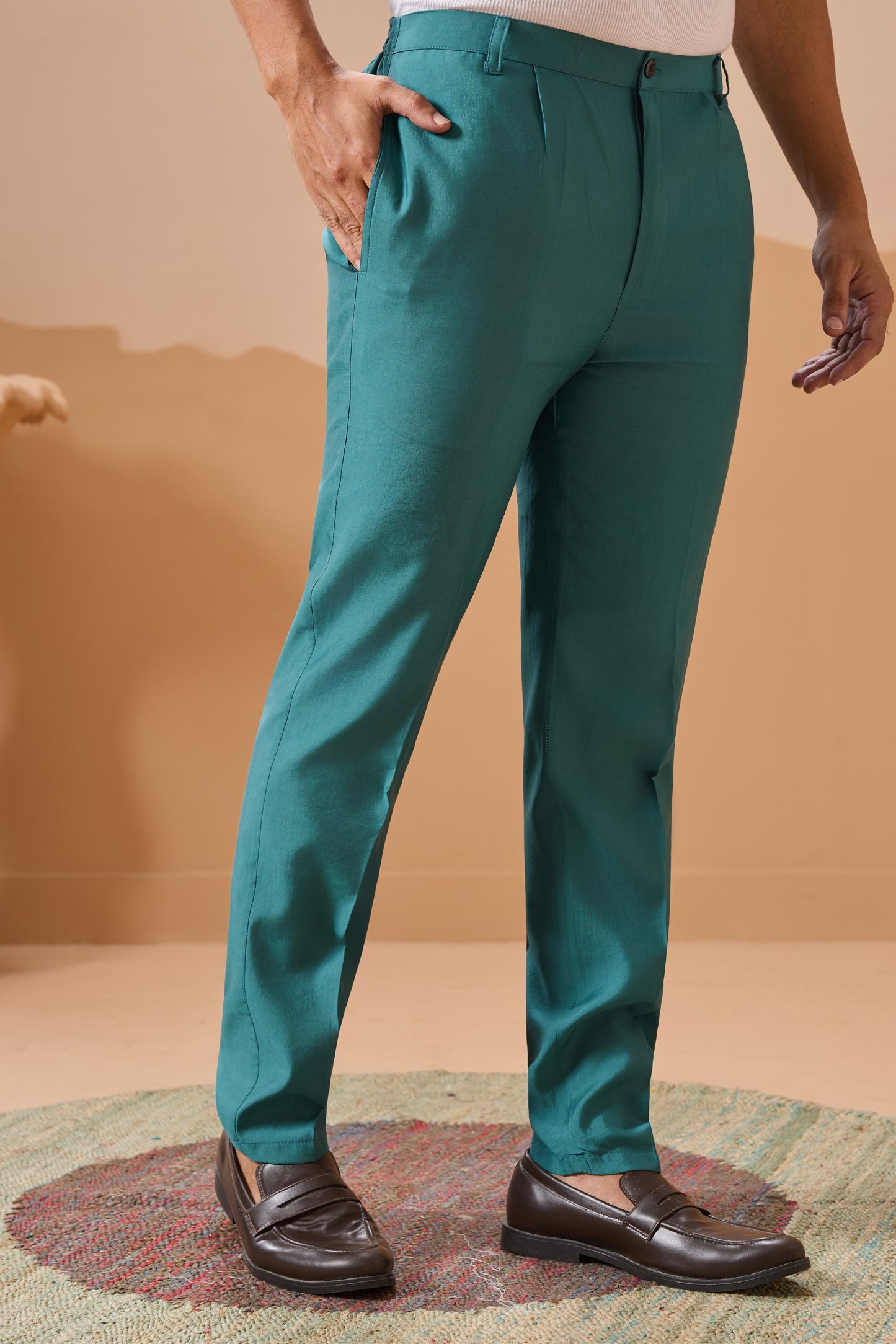 Person Wearing Teal Pants And Brown Shoes On A Beige Background

