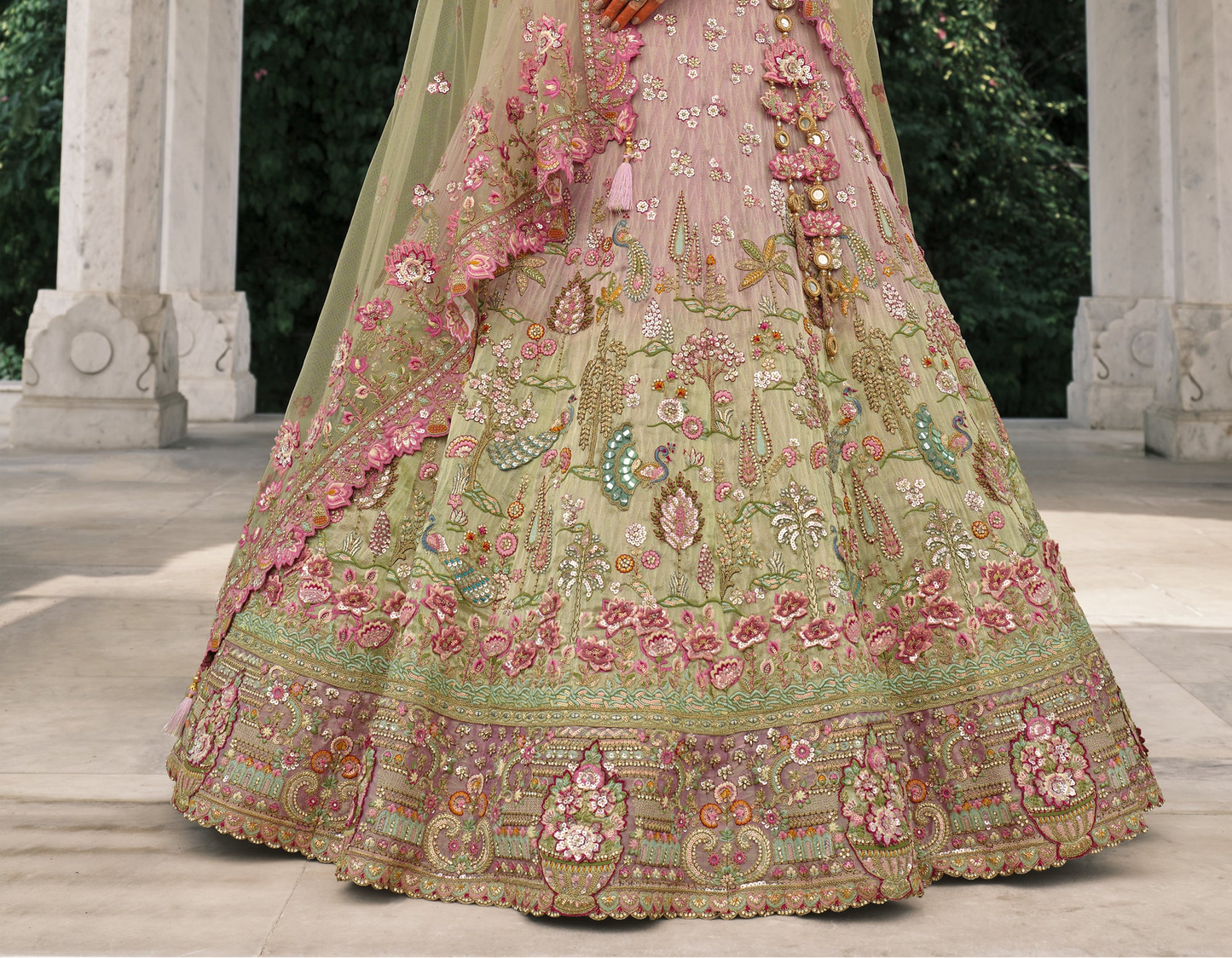 Close-up of pastel pink and green floral embroidered designer lehenga with heavy zari, thread work, sequins, and handcrafted motifs