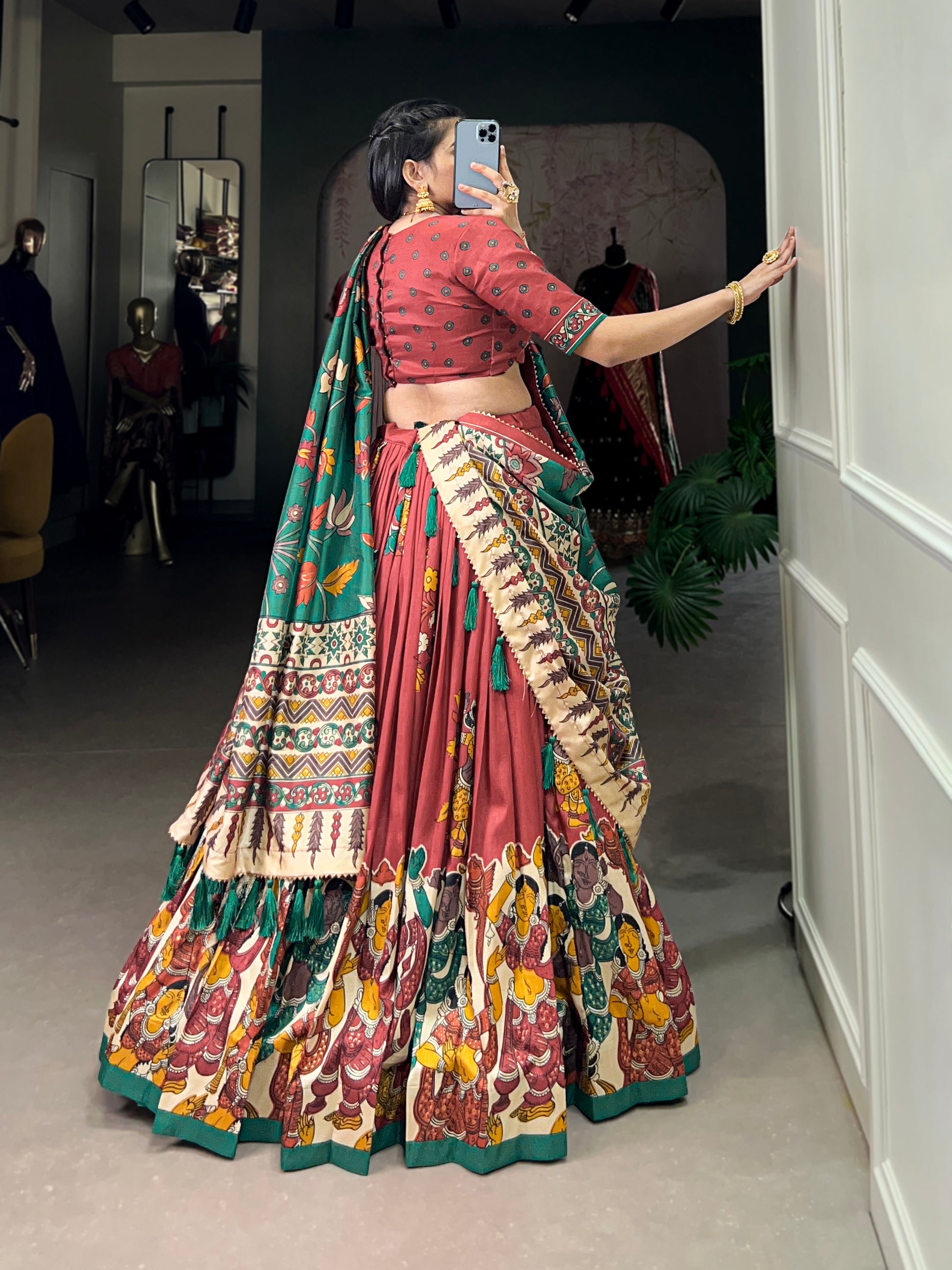 Red Tussar silk lehenga with Kalamkari print work, adorned with vibrant traditional motifs for a bold and festive look.
