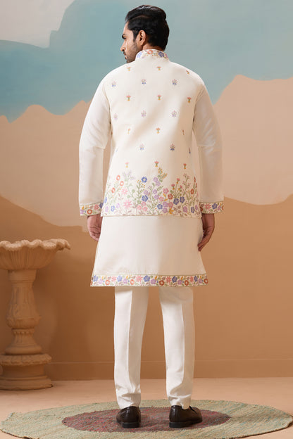 Man Wearing A Traditional Embroidered Kurta With White Pants Against A Neutral Background

