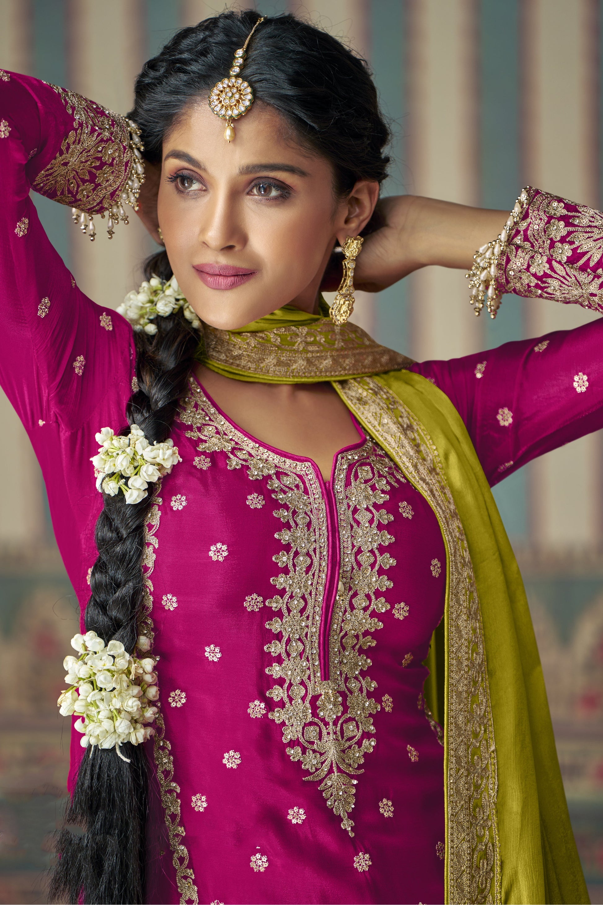 Pink color palazzo suit with embroidery work, paired with orange palazzo and a contrasting green dupatta, offering a vibrant and festive fusion perfect for traditional celebrations.
