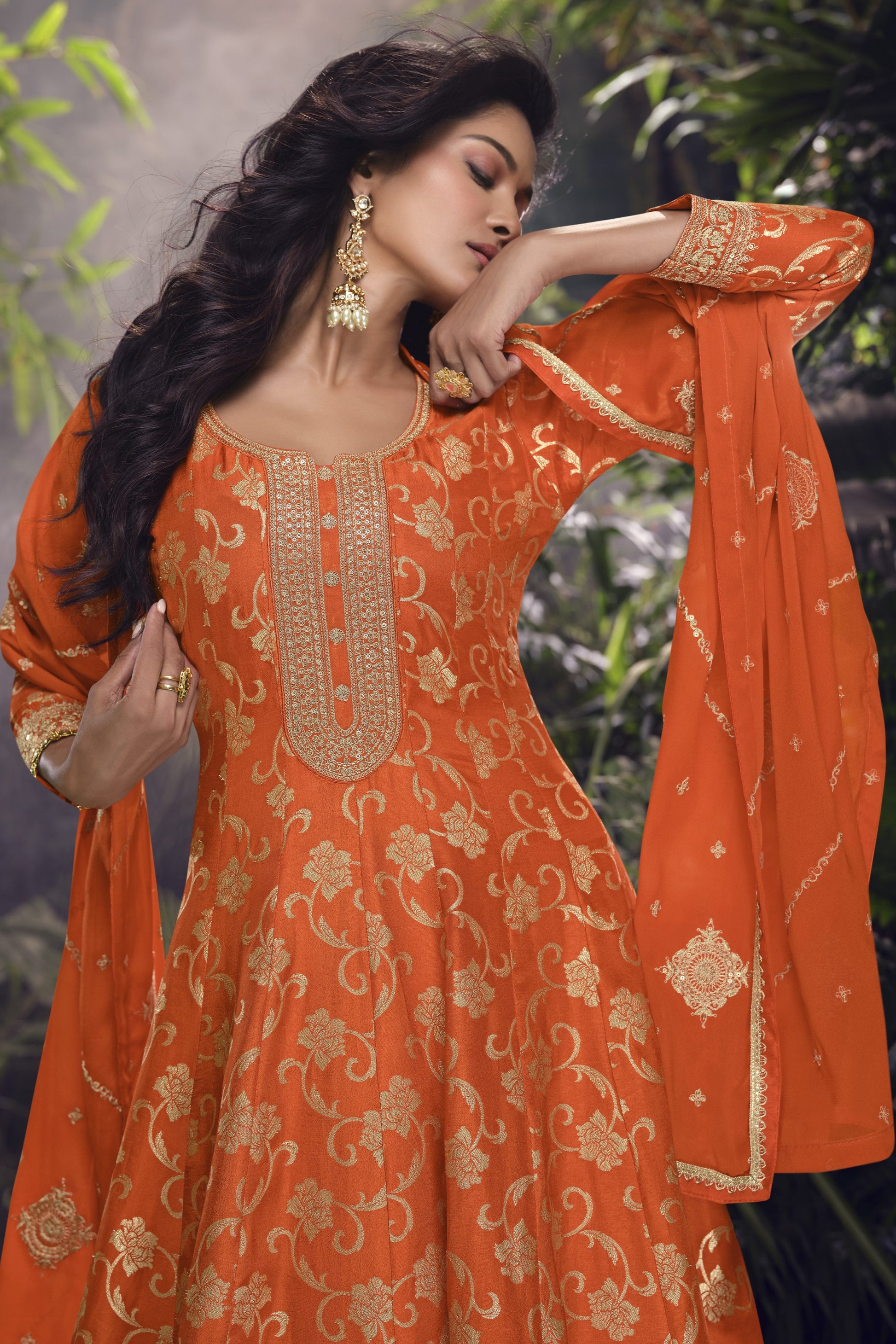 Orange color Anarkali gown in pure viscose silk with embroidery work, radiating vibrant charm perfect for festive and celebratory occasions.
