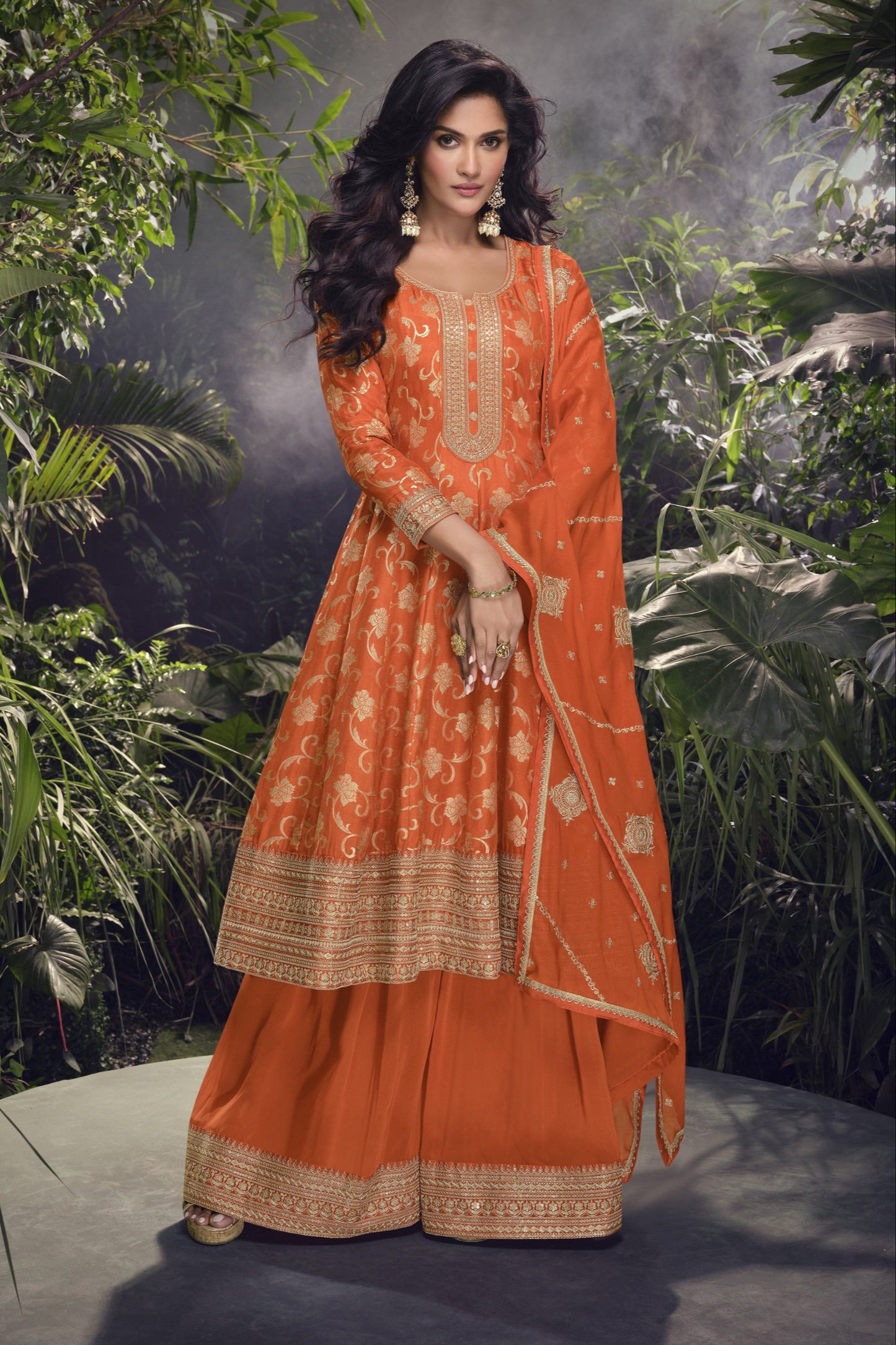 Orange color Anarkali gown in pure viscose silk with embroidery work, radiating vibrant charm perfect for festive and celebratory occasions.
