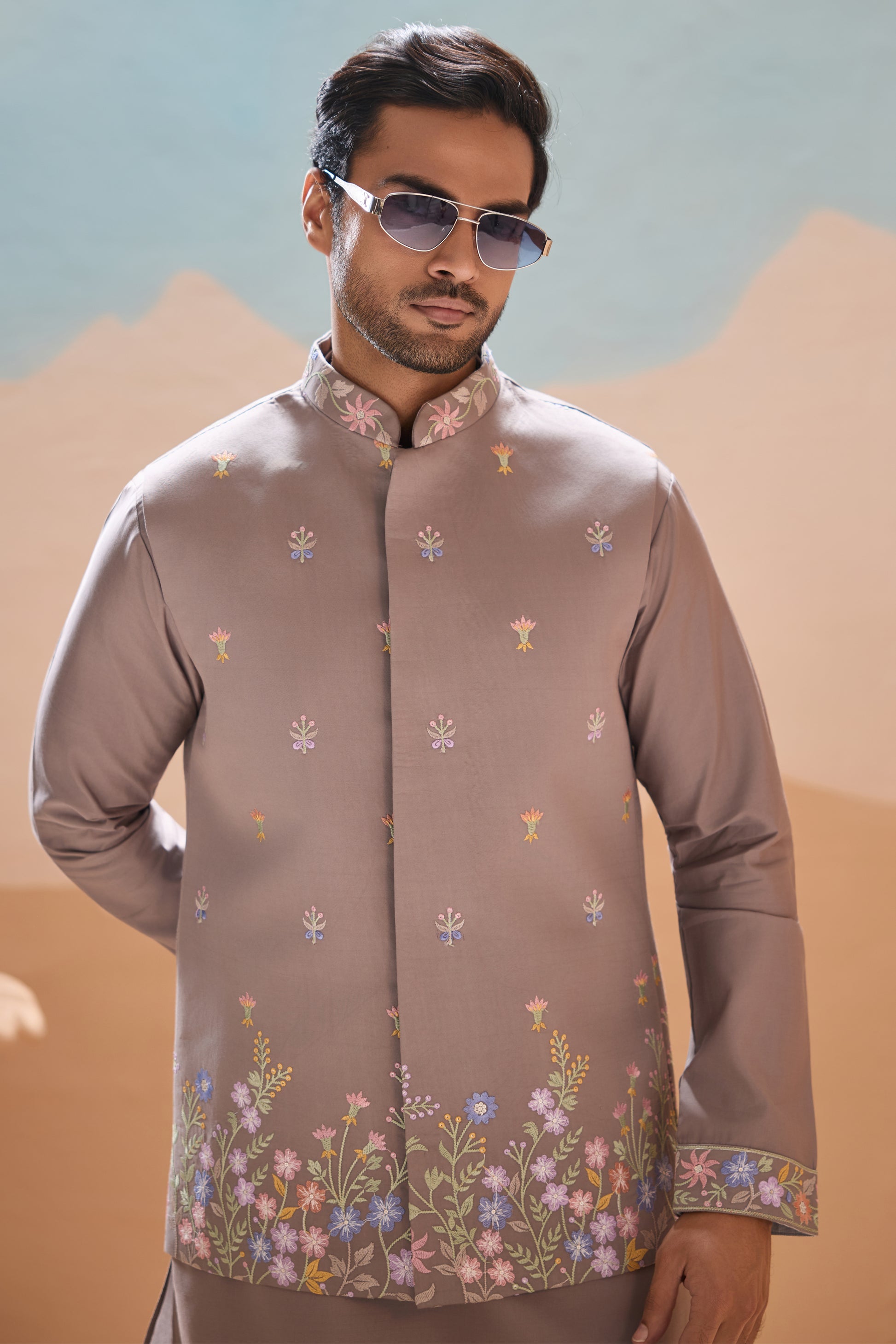 Man wearing a patterned shirt with a mountainous background