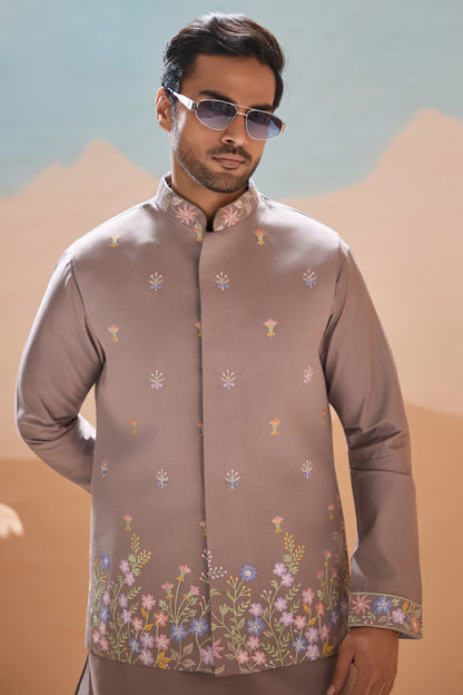 Man wearing a patterned shirt with a mountainous background