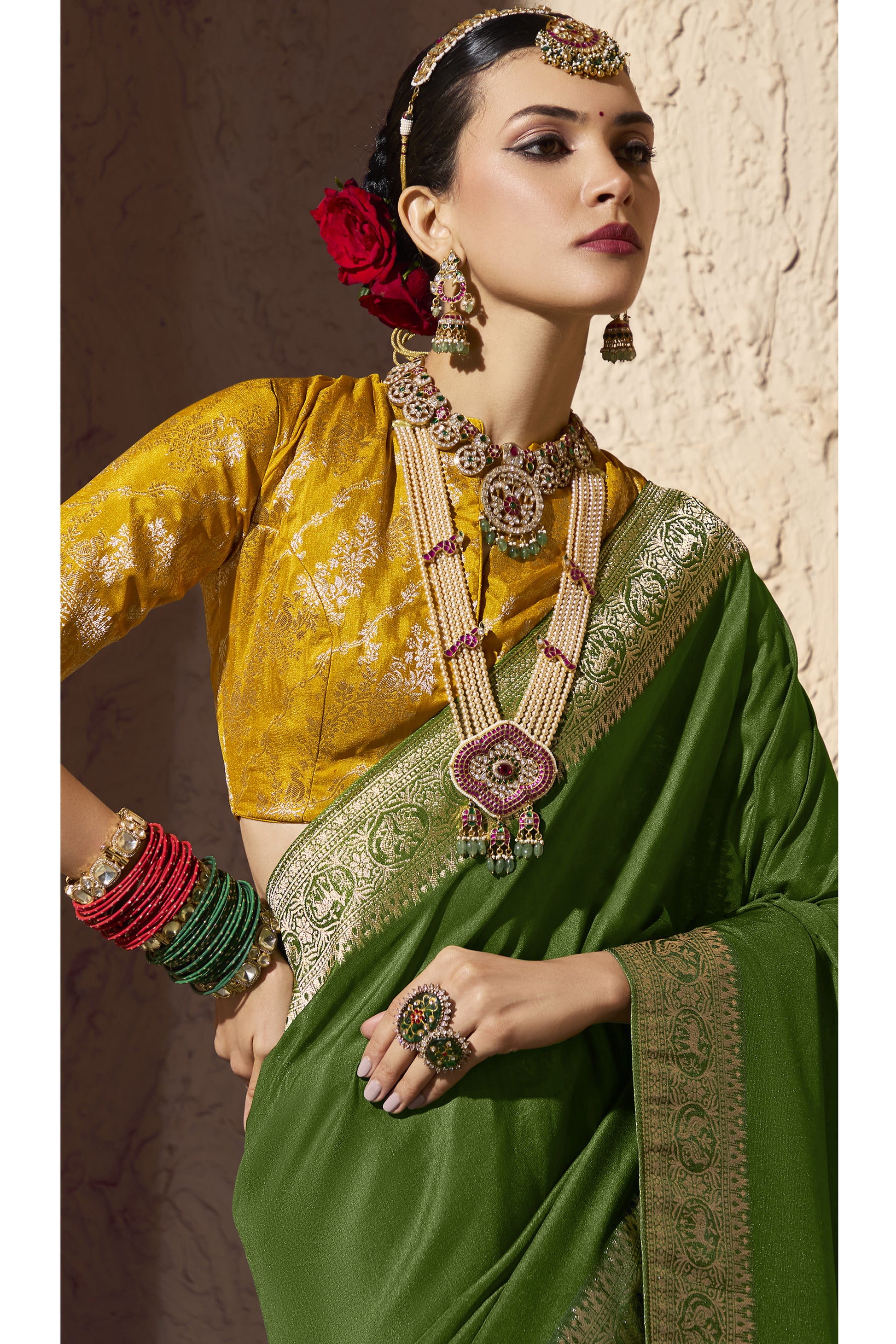 Elegant woman wearing traditional Indian silk saree in green with gold zari border, paired with mustard yellow brocade blouse, temple jewelry, bangles, and floral hair bun ,royal ethnic bridal fashion look.