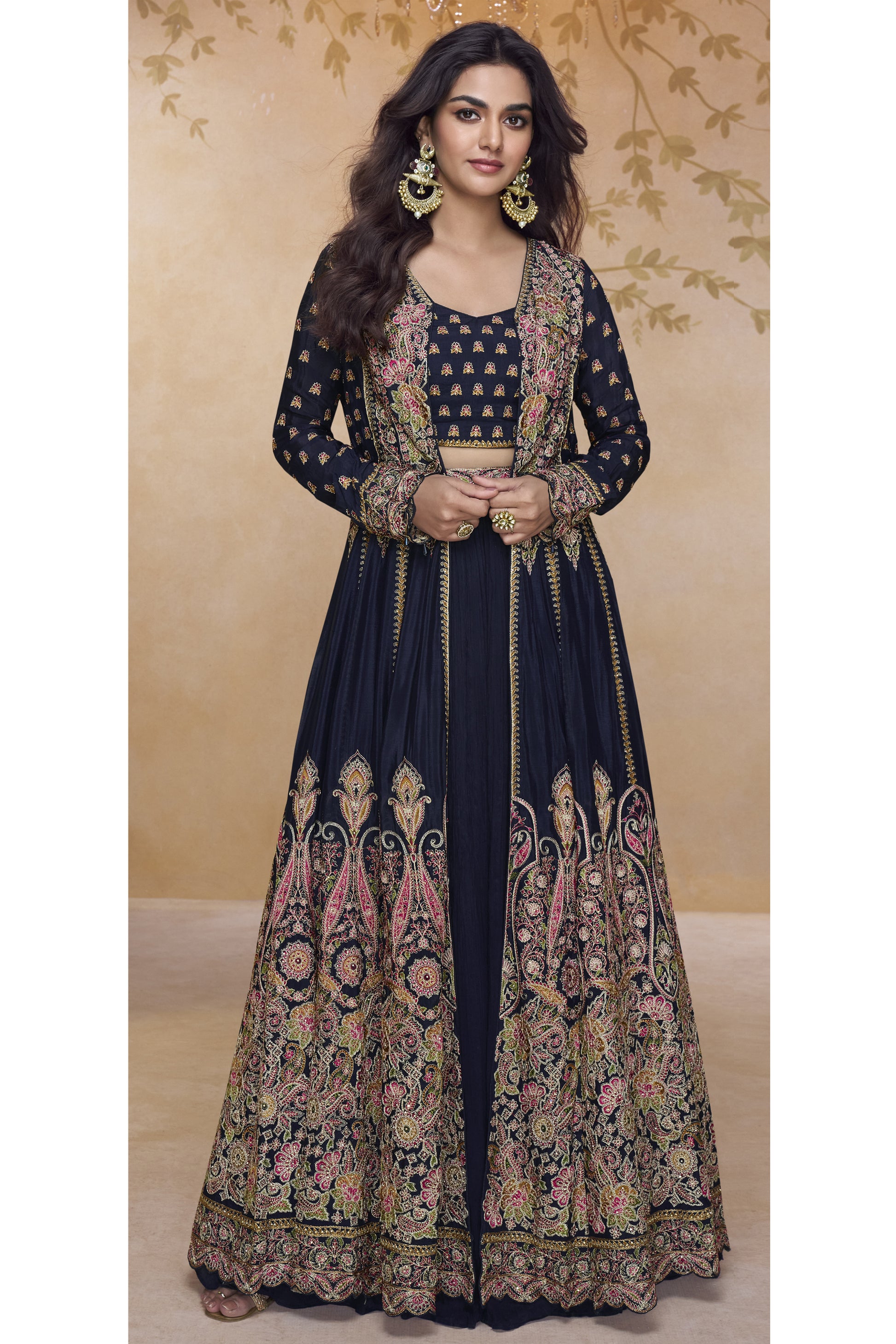 Model wearing a black heavy embroidered Anarkali gown with detailed floral zari work and jacket-style silhouette