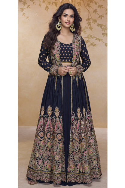 Model wearing a black heavy embroidered Anarkali gown with detailed floral zari work and jacket-style silhouette