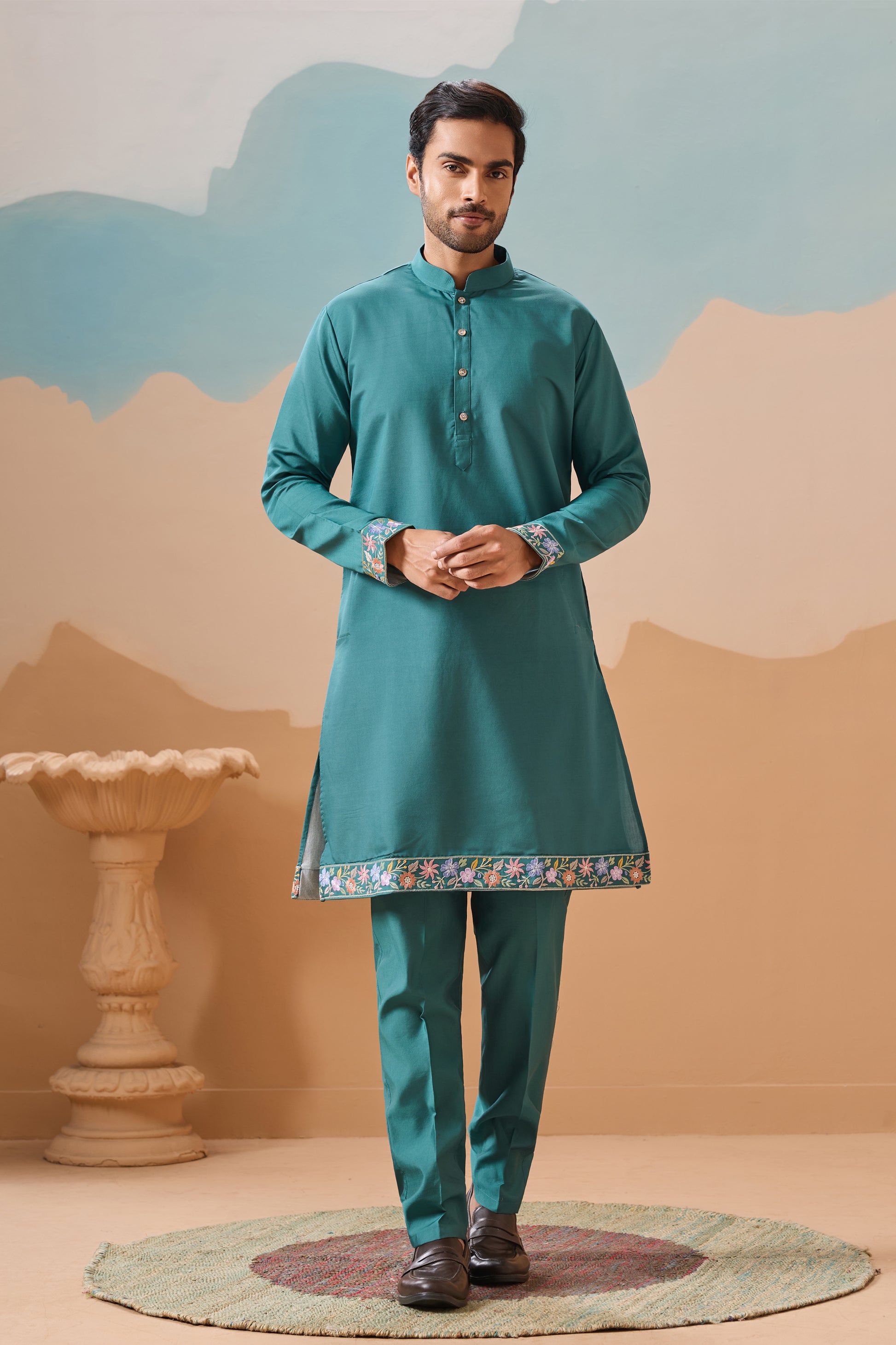Man Wearing A Teal Kurta With Pants In A Decorative Setting

