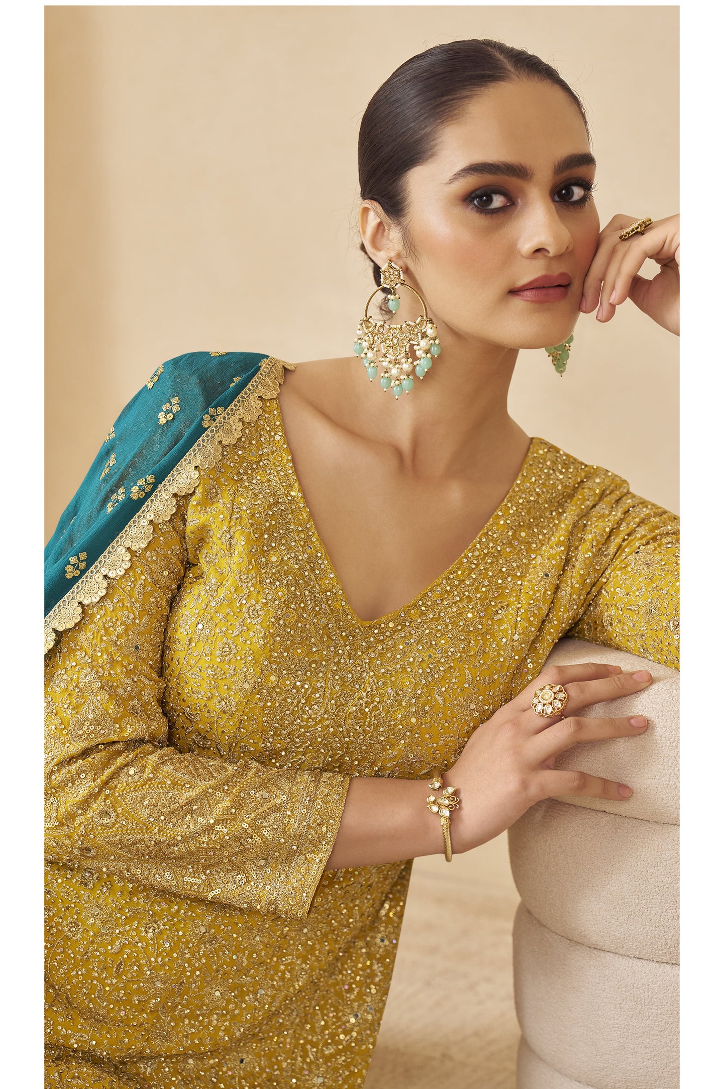 Woman wearing yellow ombré embroidered sharara suit with teal dupatta, designer ethnic wear.